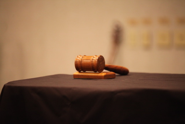 Wooden gavel on a table symbolizing law and justice in a courtroom setting.